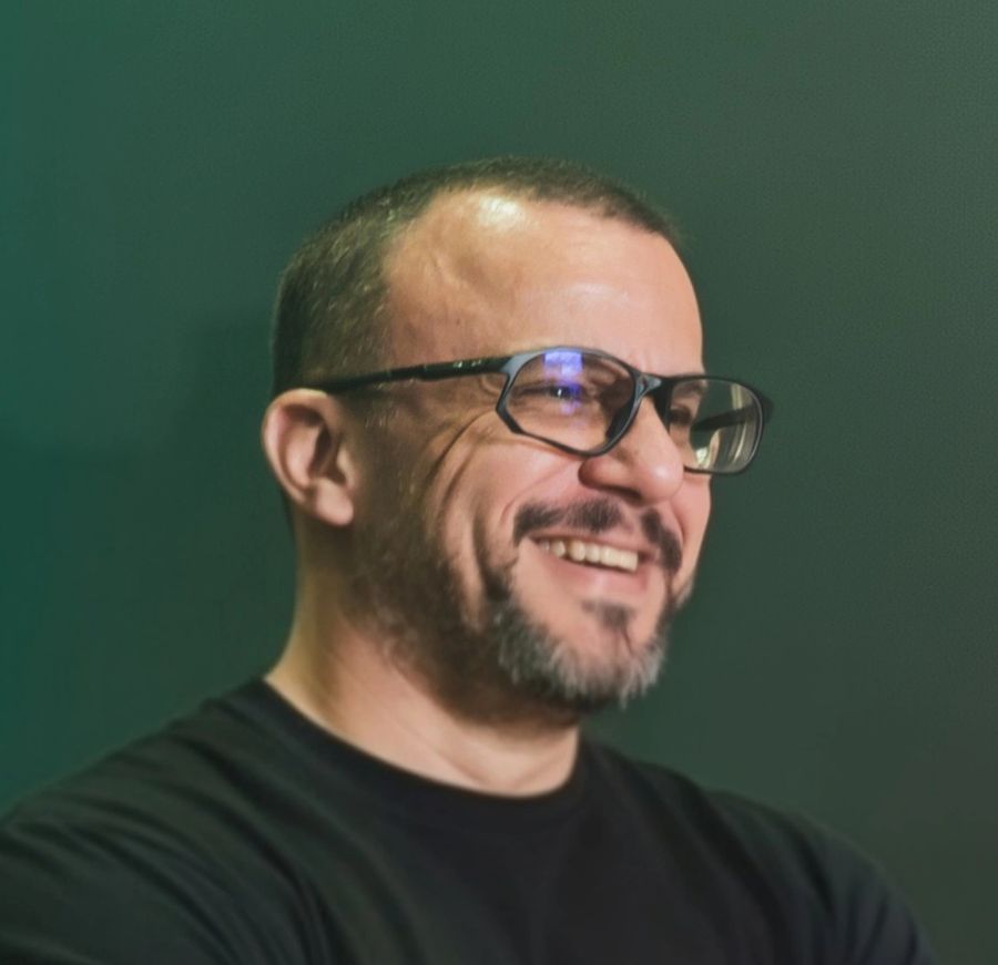 Rodrigo Rotondo sorrindo, de óculos e camiseta preta